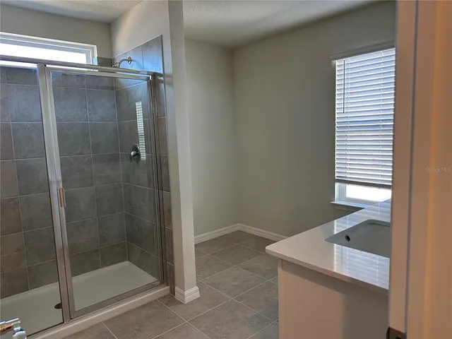 a bathroom with a shower and a sink