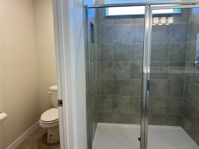 a bathroom with a toilet and a shower