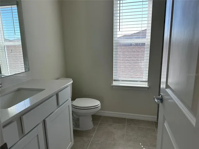 a bathroom with a sink toilet and window