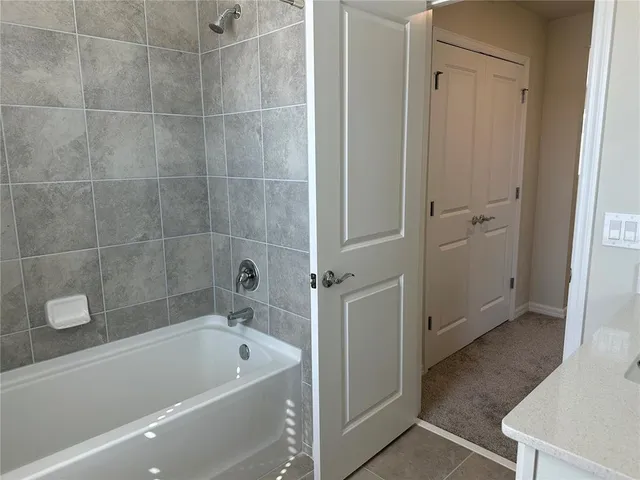 a bathroom with a tub a sink and glass door shower