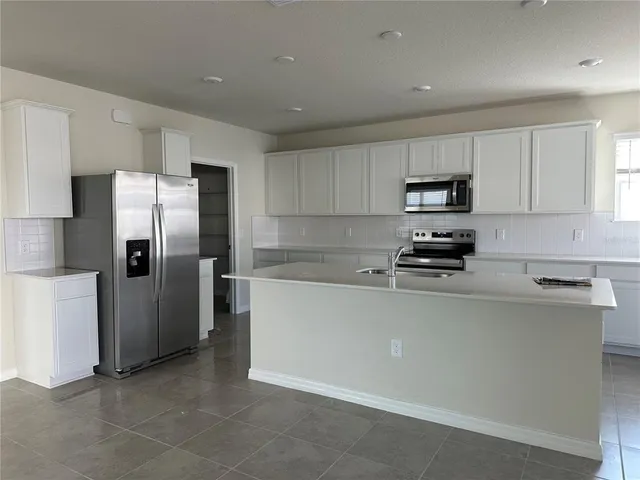 a kitchen with stainless steel appliances a refrigerator stove microwave and sink