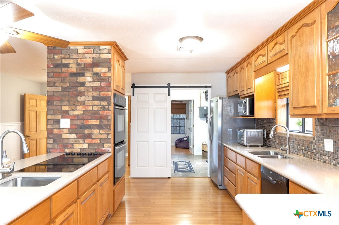 564 Cypress Valley Road Cuero, TX 77954 - Photo 12 of 40 a large kitchen with kitchen island a large window a sink and stainless steel appliances