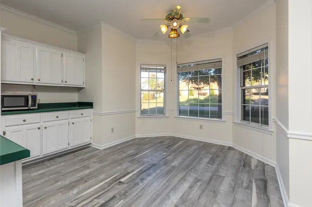 a view of an empty room with a window and wooden floor