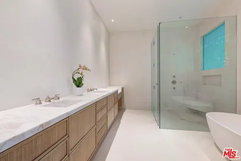 a bathroom with a double vanity sink toilet and shower