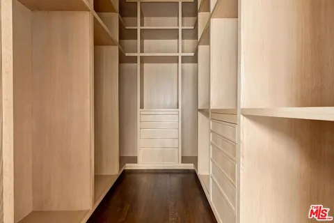 a view of walk in closet with empty racks