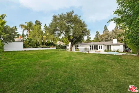 a view of house with garden space and trees
