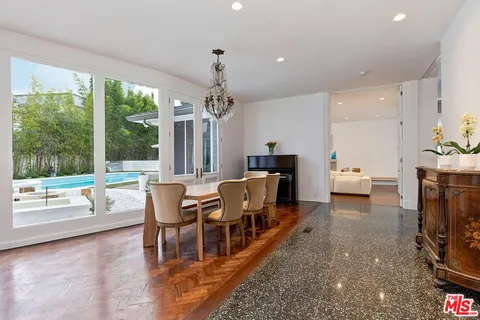 a living room with furniture a flat tv screen and a floor to ceiling window