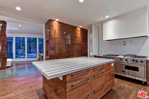 a kitchen with a stove and a wooden floor