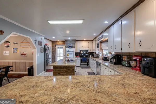 a bathroom with a granite countertop sink a toilet and a mirror