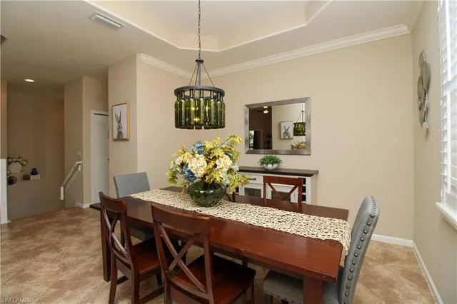 a dining room with furniture a chandelier and window