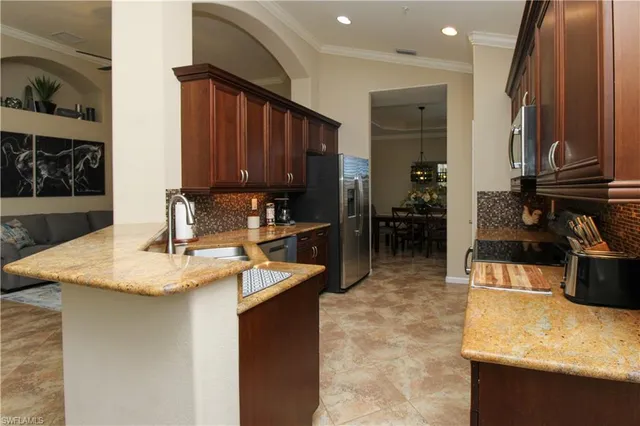 a kitchen with stainless steel appliances granite countertop a sink refrigerator and cabinets