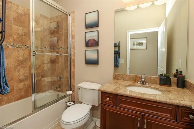 a bathroom with a granite countertop sink toilet mirror and shower