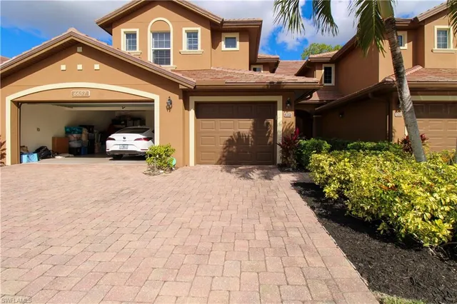 a view of a house with a yard and potted plants