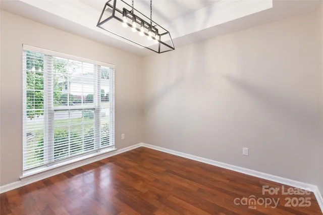 a view of a big room with wooden floor and windows