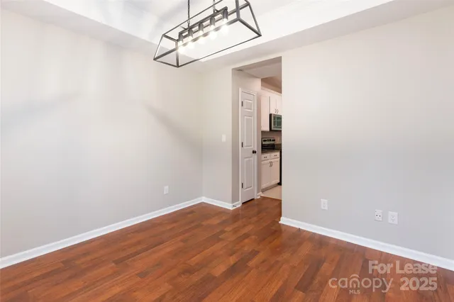 a view of a room with wooden floor and an entryway