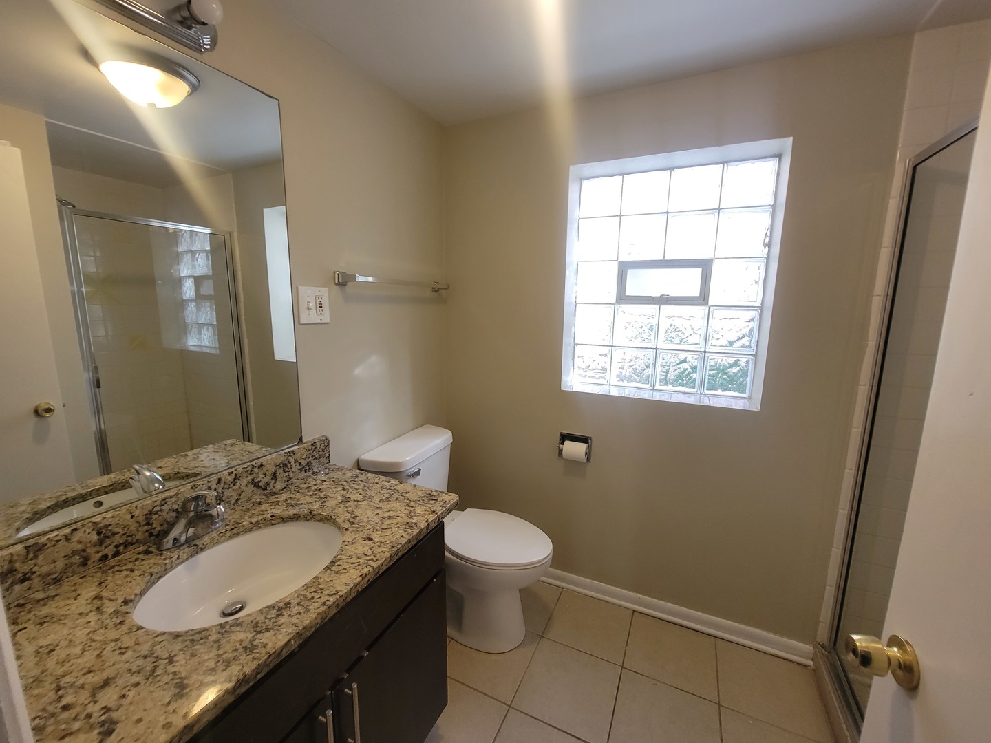 5237 West Roscoe Street Chicago, IL 60641 - Photo 13 of 27 a bathroom with a granite countertop sink toilet and shower