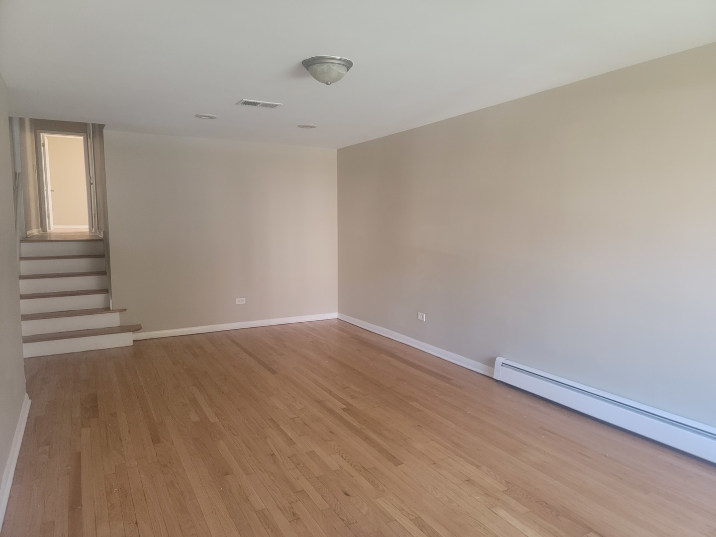 5237 West Roscoe Street Chicago, IL 60641 - Photo 3 of 27 a view of an empty room with wooden floor and a window