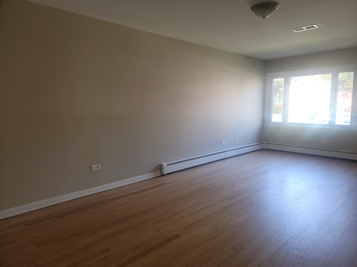 5237 West Roscoe Street Chicago, IL 60641 - Photo 4 of 27 an empty room with wooden floor and windows