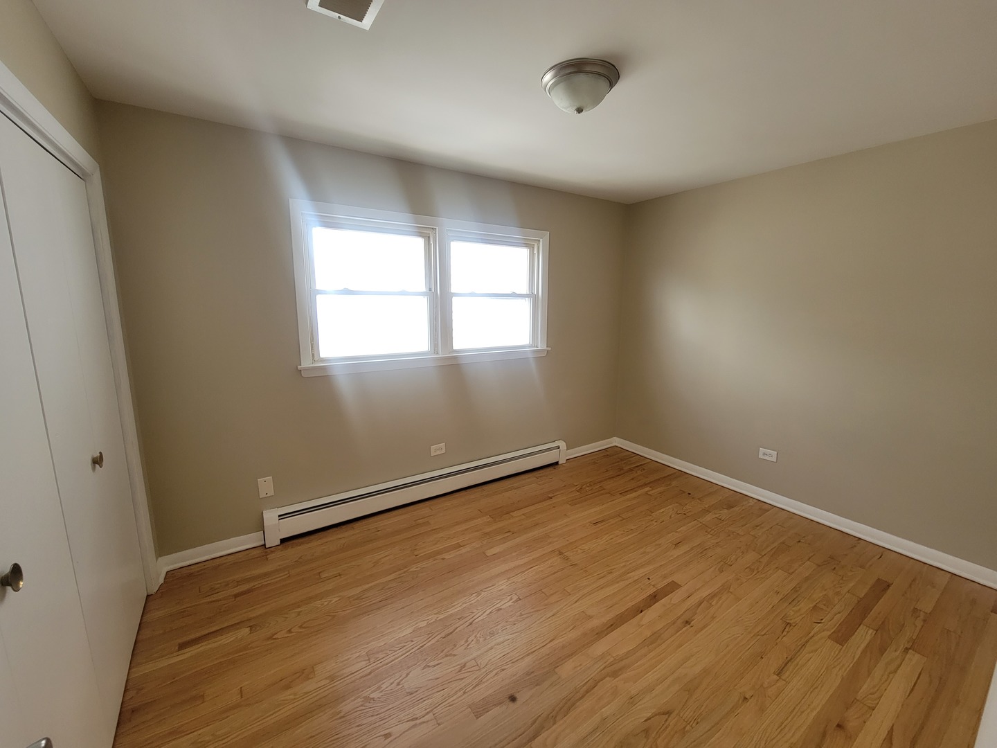 5237 West Roscoe Street Chicago, IL 60641 - Photo 7 of 27 an empty room with wooden floor and windows