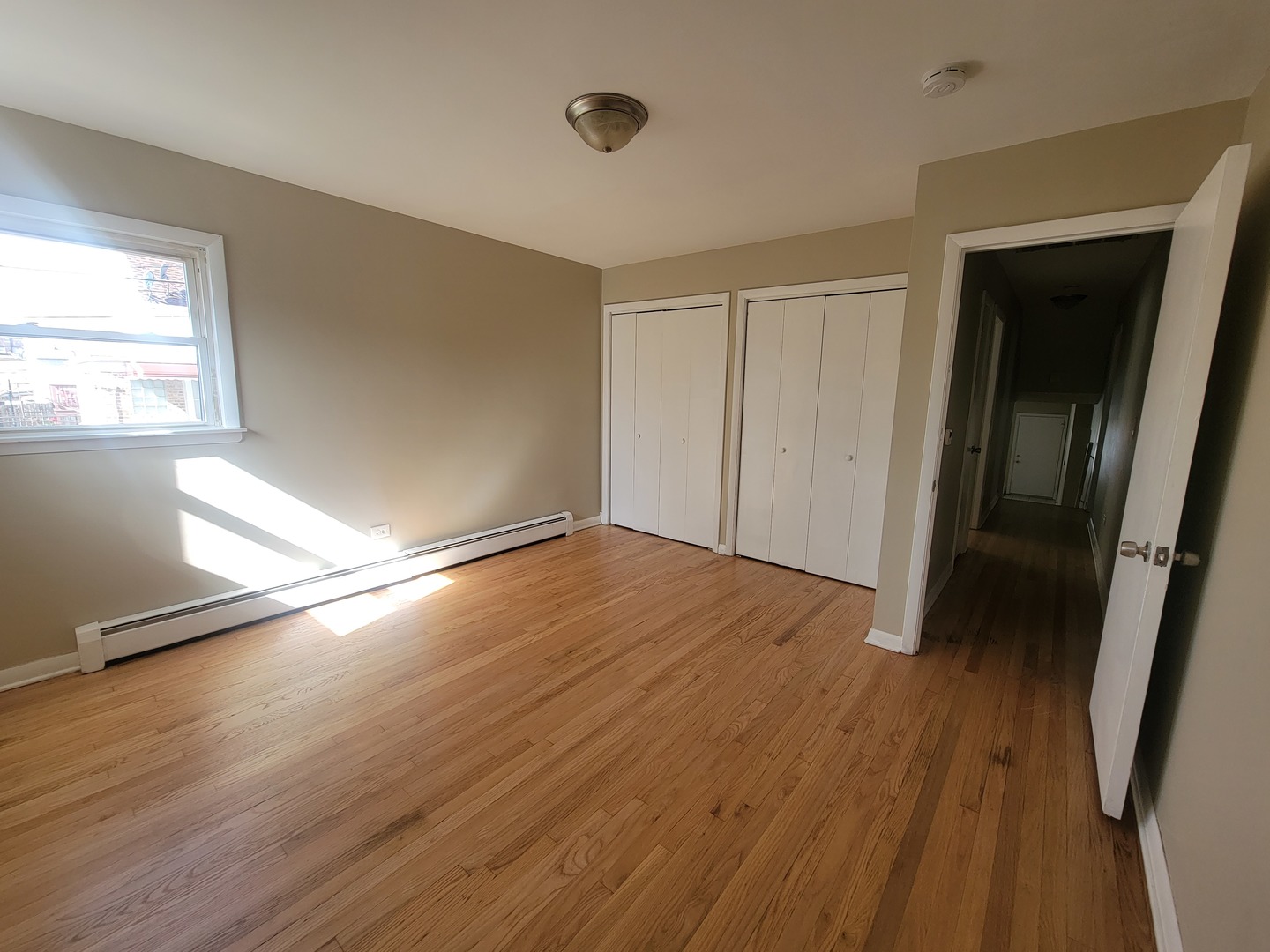 5237 West Roscoe Street Chicago, IL 60641 - Photo 8 of 27 an empty room with wooden floor and windows