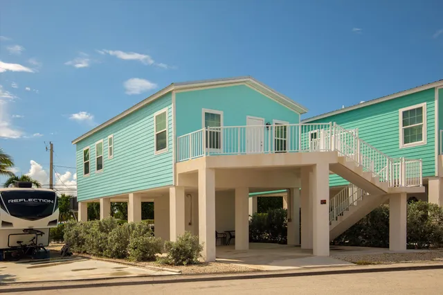 a front view of a house with yard and parking
