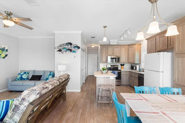 a kitchen with sink refrigerator dining table and chairs