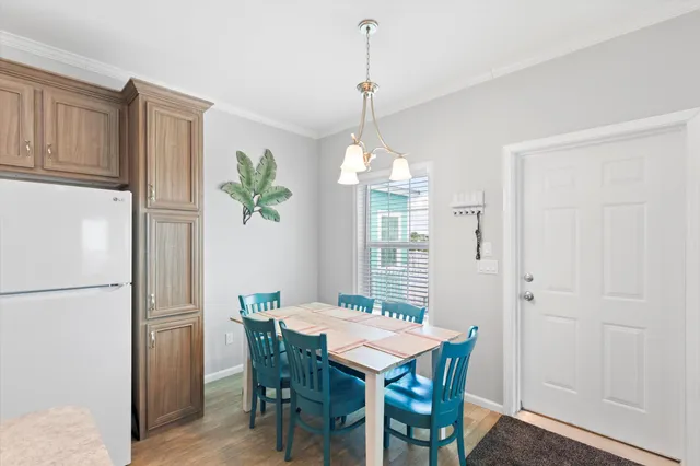 a bedroom with a bed a chandelier and a dresser in it