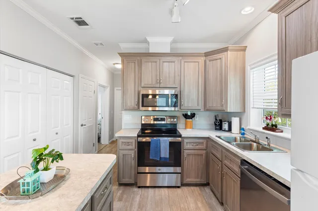 a kitchen that has a sink a refrigerator and a stove