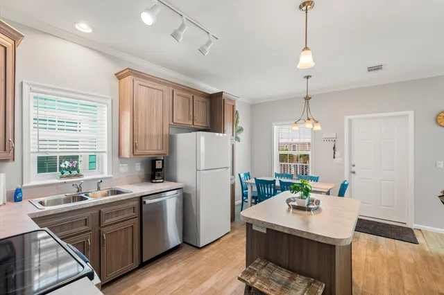 a kitchen with sink refrigerator dining table and chairs