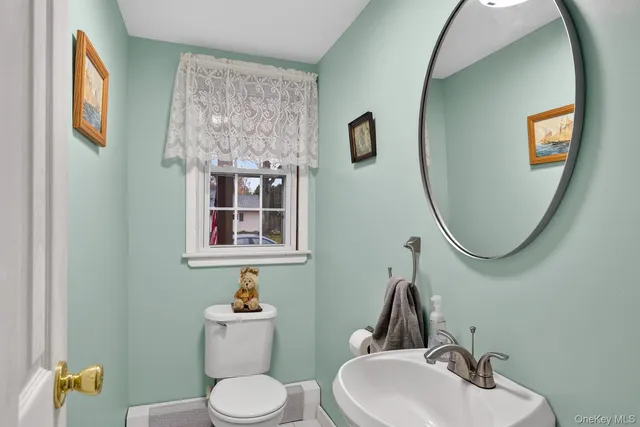 a bathroom with a toilet a sink and mirror