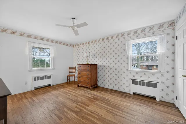 a view of empty room with a window and wooden floor