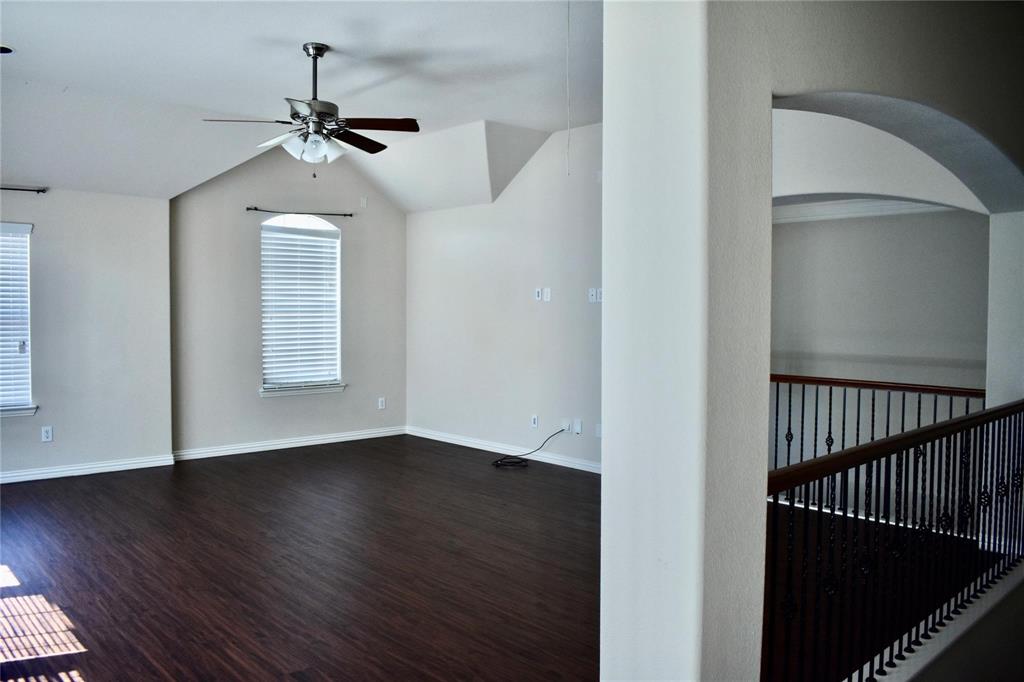384 Spring Meadow Drive Fairview, TX 75069 - Photo 11 of 16 an empty room with wooden floor chandelier fan and windows