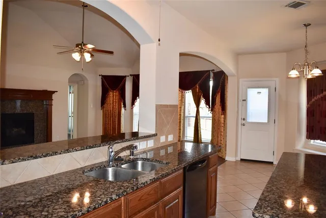 a kitchen with stainless steel appliances granite countertop a sink a stove and a wooden floors