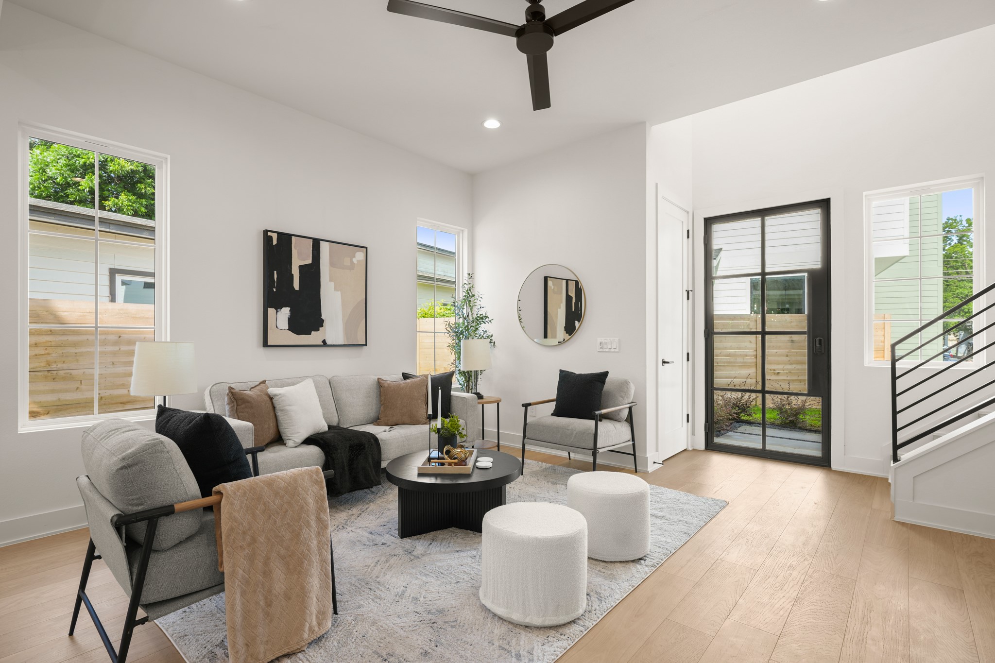 Natural light floods this inviting living space, highlighting modern design and gleaming hardwood flooring.