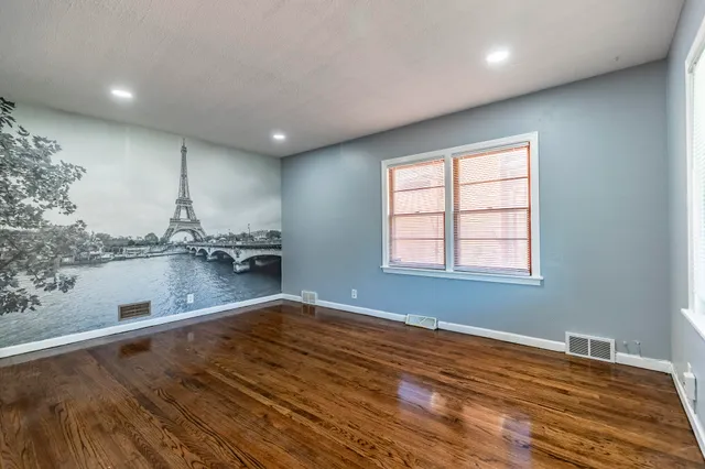 an empty room with window and wooden floor