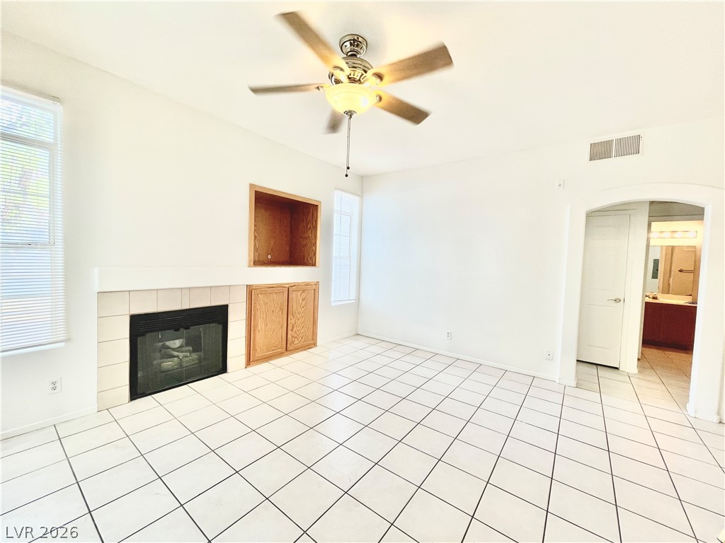 2201 Ramsgate Drive, Unit 915 Henderson, NV 89074 - Photo 17 of 36 A cozy living space features a tiled fireplace with built-in storage and a ceiling fan.