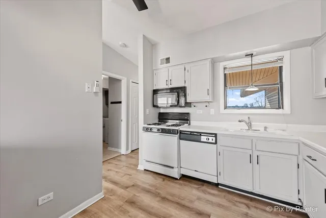 a kitchen with stainless steel appliances white cabinets and a refrigerator