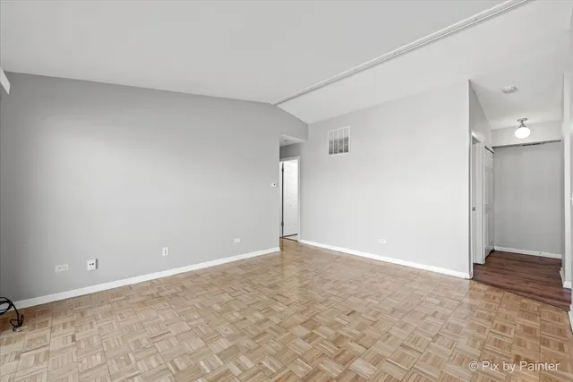 a view of empty room with kitchen