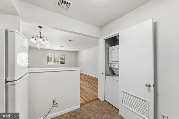 a view of a hallway with white cabinets and wooden floor