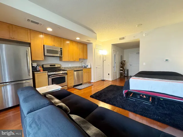 a kitchen with stainless steel appliances granite countertop a sink dishwasher stove refrigerator and microwave