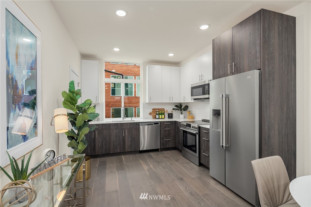 13735 35th Avenue Northeast, Unit B Seattle, WA 98125 - Photo 6 of 20 a kitchen with stainless steel appliances a refrigerator a stove a sink a couch and chairs