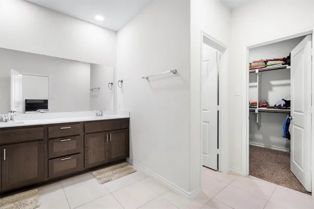 a spacious bathroom with a double vanity sink and a mirror