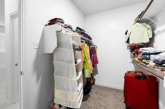 a view of walk in closet with clothes and shoes