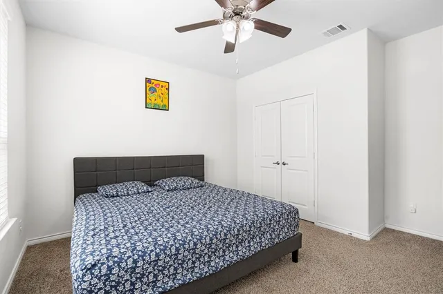 a bedroom with a bed and painting on the wall