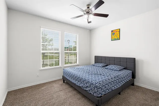 a bedroom with a large bed a chandelier and a window