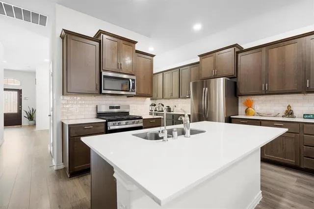 a kitchen with refrigerator cabinets and wooden floor