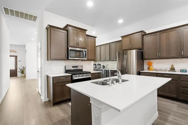a kitchen with kitchen island a sink stove and refrigerator