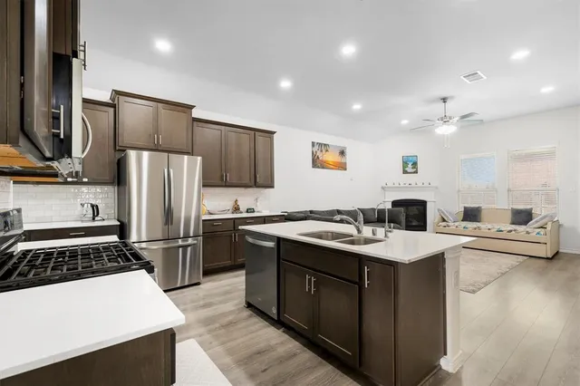 a kitchen with stainless steel appliances a sink stove and refrigerator