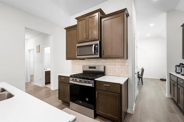 a kitchen with stainless steel appliances a stove a sink and a microwave