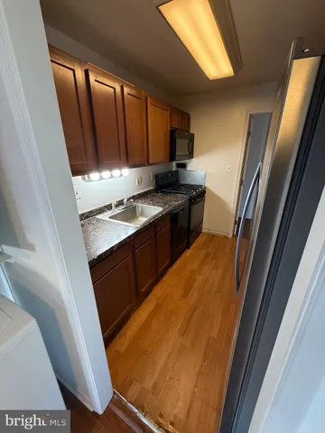 a kitchen with granite countertop sink stove and cabinets